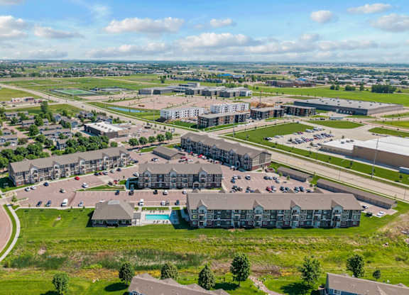 A large, modern building complex with a parking lot in front.