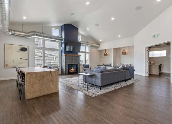 A modern living room with a fireplace and a grey sofa.