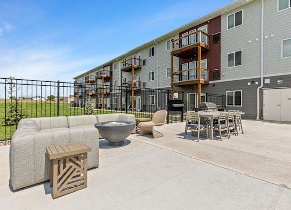 our apartments have a large patio with furniture and a fire pit