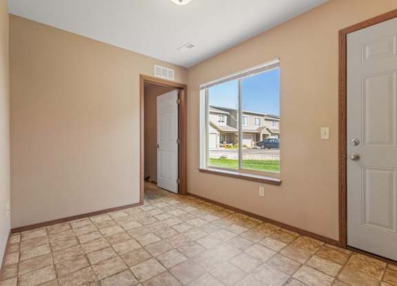 A room with a tiled floor and a view of a building outside the window.