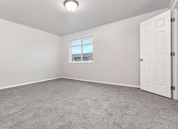 A room with a carpeted floor and a window.