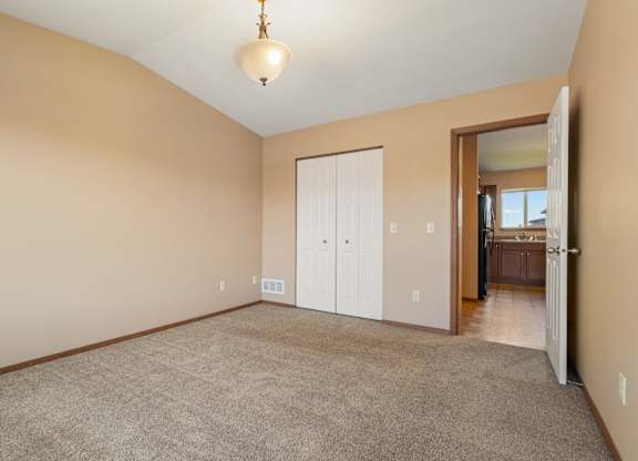A room with a carpeted floor and a white door.