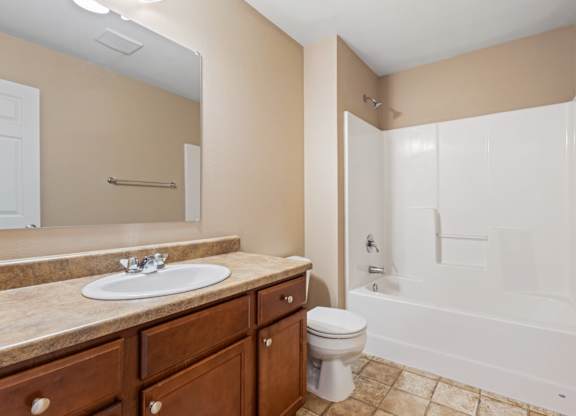 A bathroom with a sink, toilet, and bathtub.