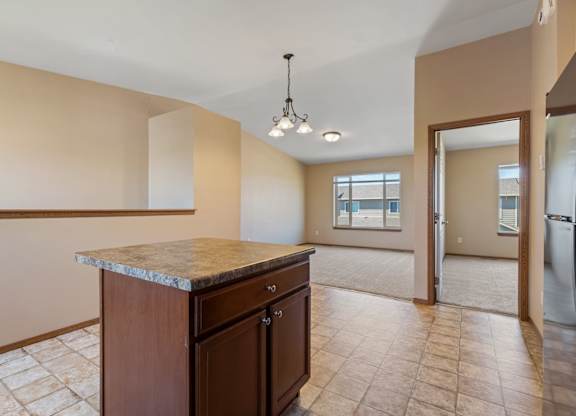 A kitchen with a marble countertop and tile flooring.