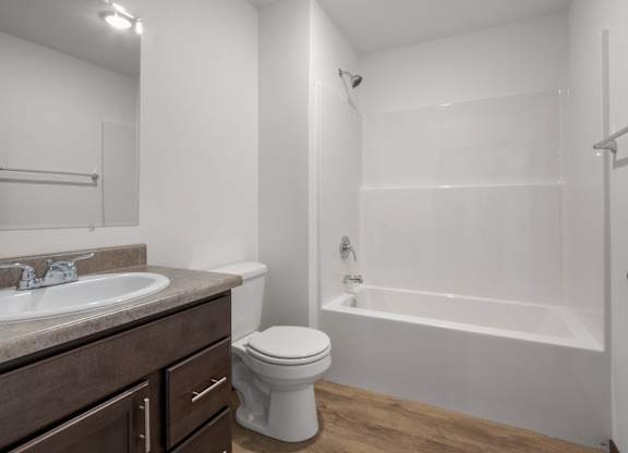 A white bathroom with a toilet, sink, and bathtub.