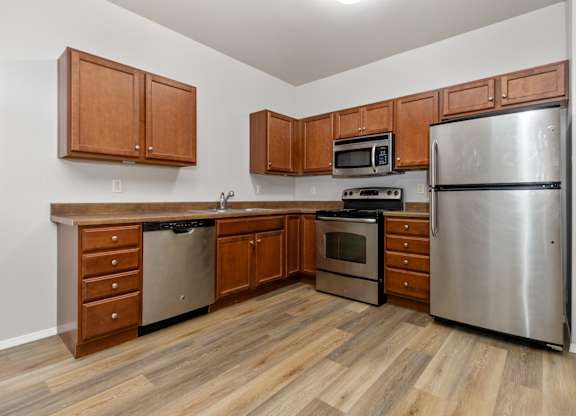 A kitchen with wooden cabinets and stainless steel appliances.