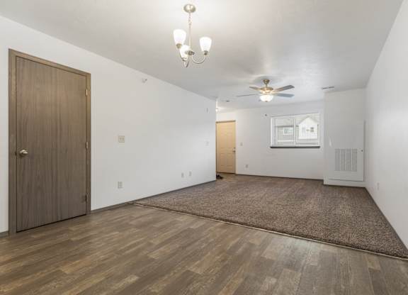 A room with a brown door and a ceiling fan.