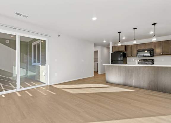 A modern kitchen with a white countertop and a wooden floor.