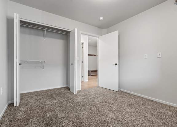 A room with a carpeted floor and a white door.