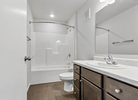 A bathroom with a toilet, sink, and a walk-in shower.