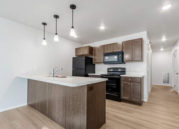 A kitchen with a white counter top and wooden cabinets.