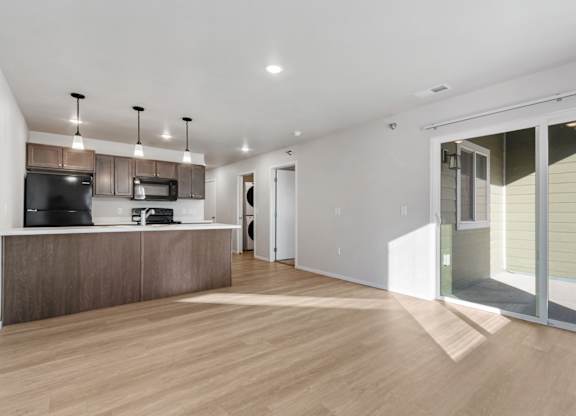 A modern kitchen with a wooden floor and white walls.