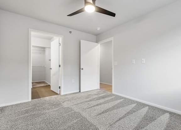 A room with a ceiling fan and a carpeted floor.