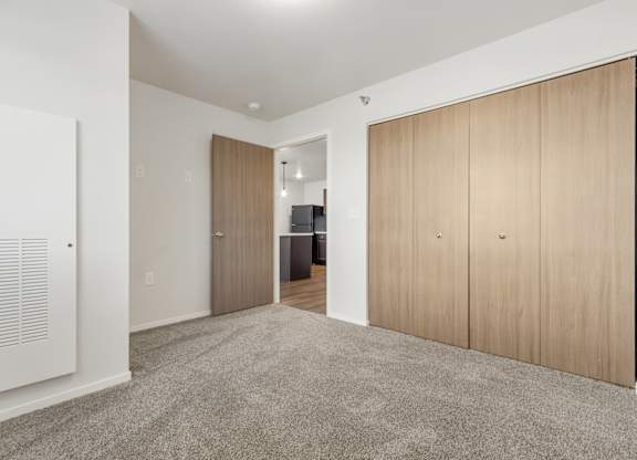 A room with a carpeted floor and wooden doors.
