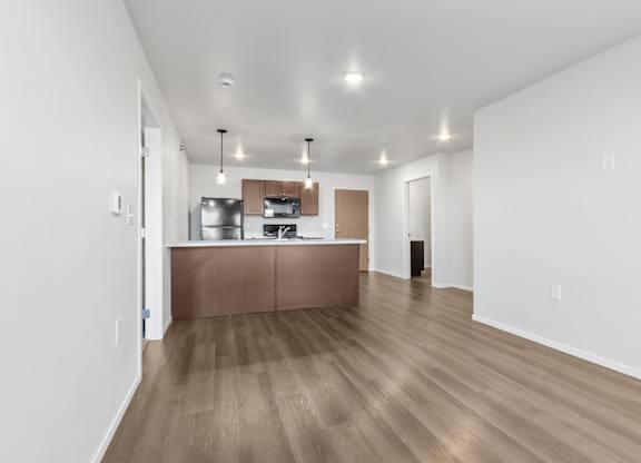 A kitchen with a wooden floor and white walls.