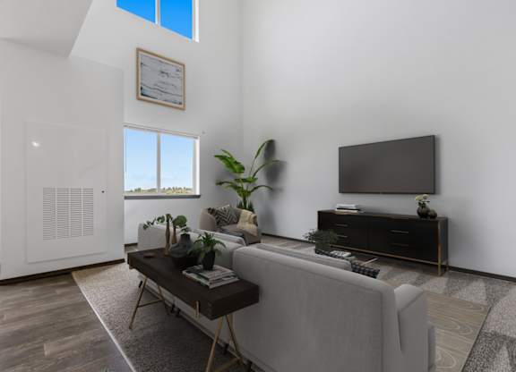 A living room with a grey couch, a coffee table, and a flat screen TV.