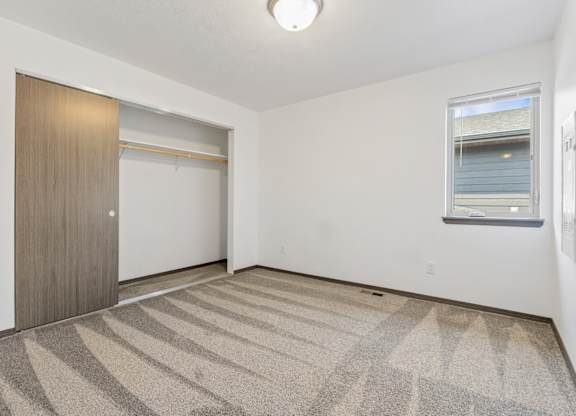 A room with a carpeted floor and a sliding door.