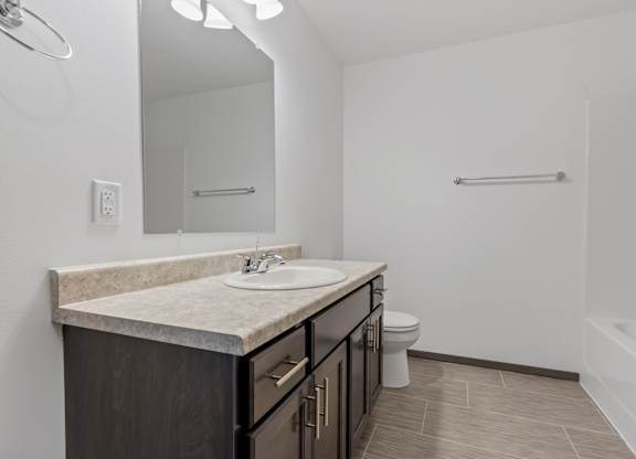 A bathroom with a sink, toilet, and bathtub.