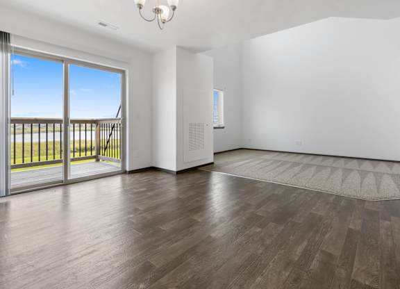 A room with a sliding glass door leading to a balcony.