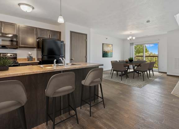 A kitchen with a bar area and a dining table.