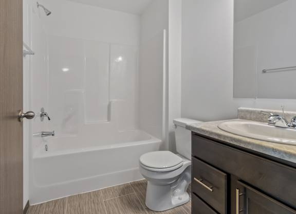 A white toilet sits in a bathroom next to a sink.