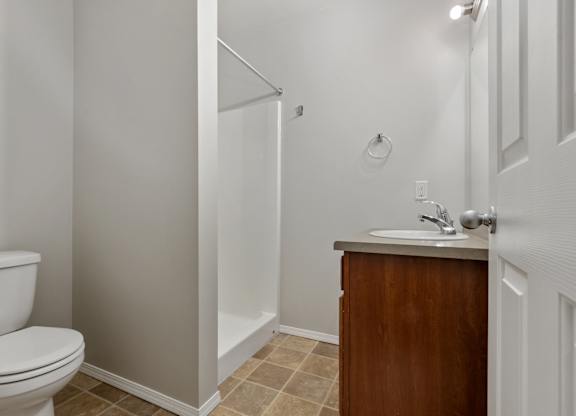 A white toilet sits next to a sink in a small bathroom.