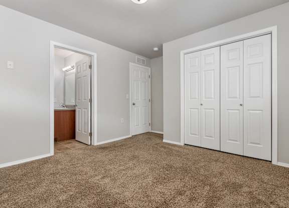 A room with white walls and brown carpet.