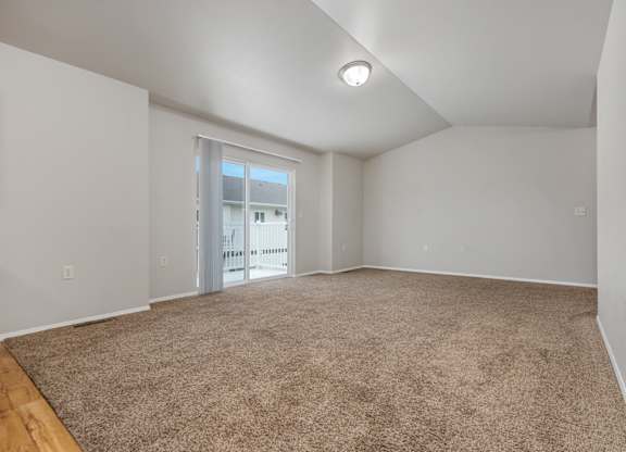 A room with a carpeted floor and a window.