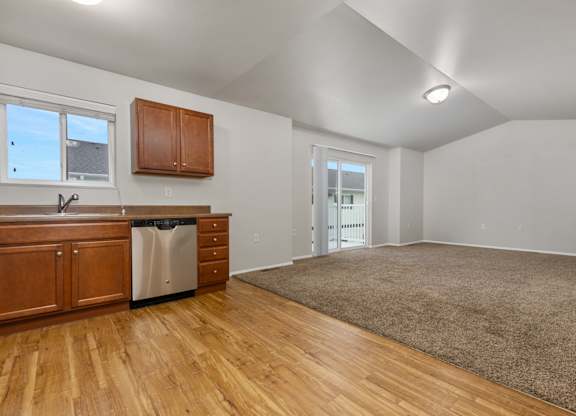 A kitchen with wooden cabinets and a stainless steel dishwasher.