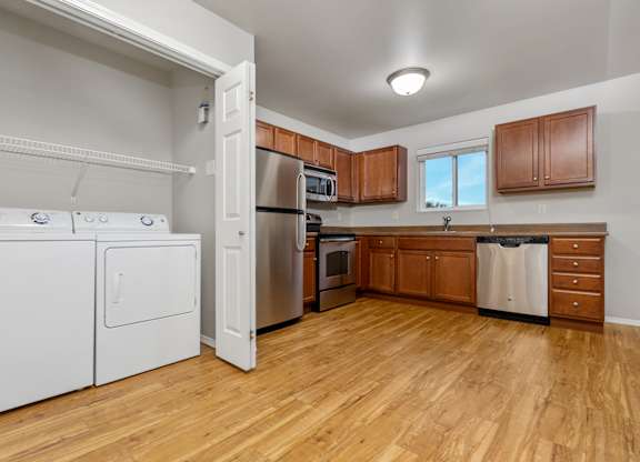A kitchen with wooden floors and white appliances.