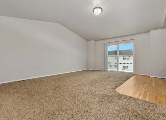 Empty room with carpeted floor and a window.