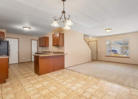 A kitchen area with a tile floor and a chandelier hanging from the ceiling.