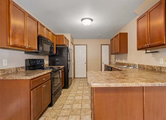 A kitchen with brown cabinets and granite countertops.