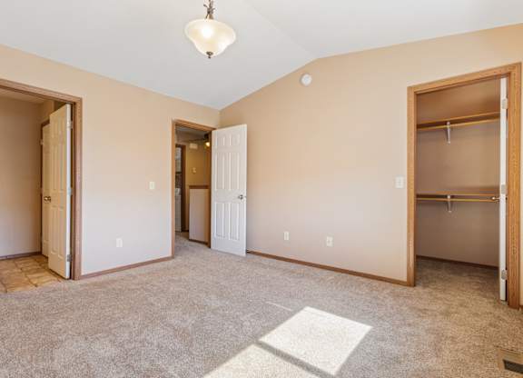A spacious room with a carpeted floor and a ceiling light.