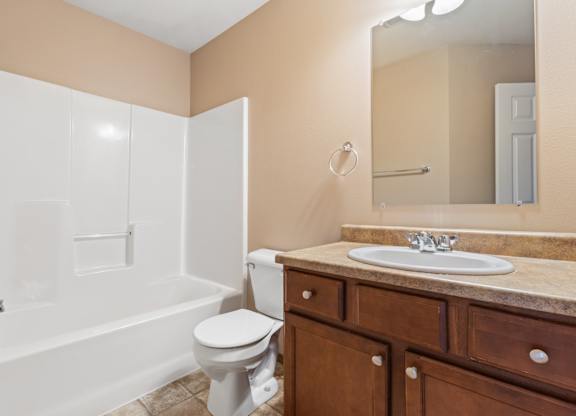 A bathroom with a white toilet, sink, and bathtub.