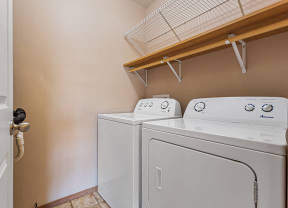 A white washing machine and dryer in a laundry room.