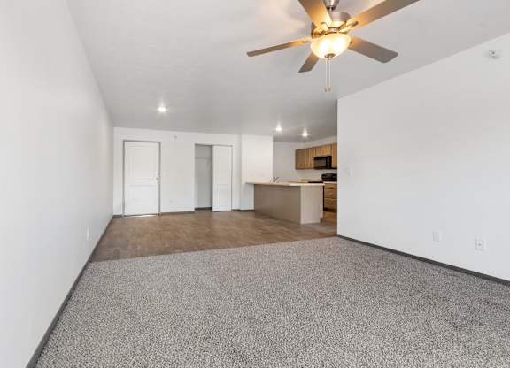 A room with a ceiling fan and carpeted floor.