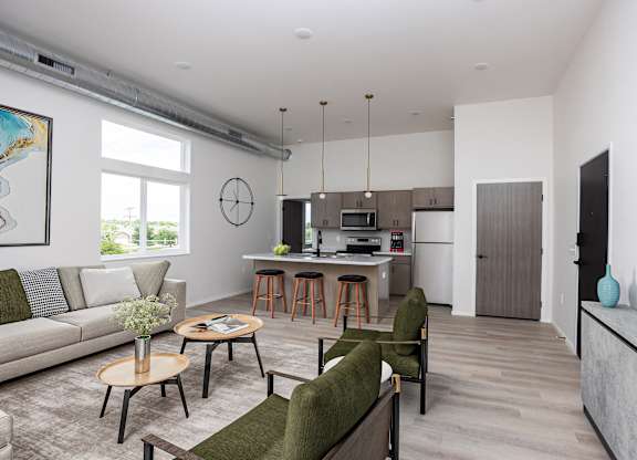 A living room with a couch, chairs, and a dining table.