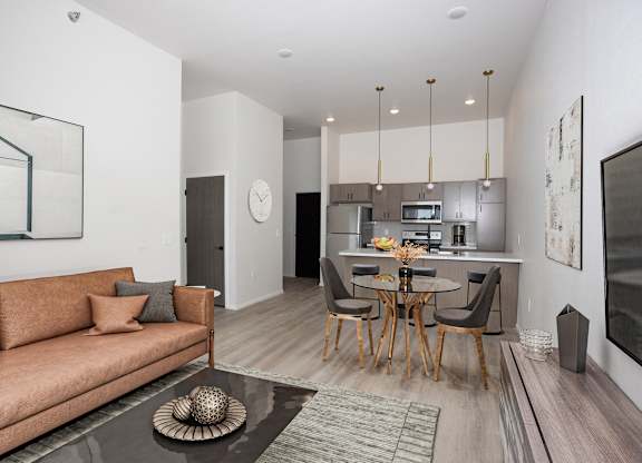 A modern living room with a brown sofa and a glass coffee table.