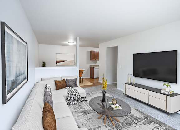 A living room with a white couch, a coffee table, and a large painting on the wall.