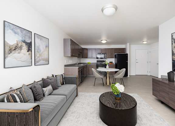 A living room with a grey couch and a coffee table in the middle.