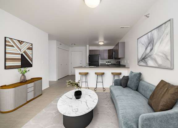 A modern living room with a grey couch and a marble coffee table.