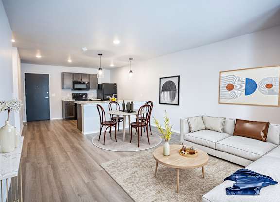 A modern living room with a dining table set up in the middle.