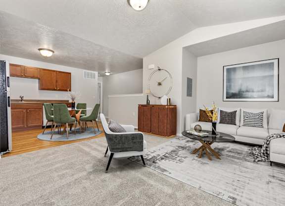 A living room with a grey rug and a white couch.