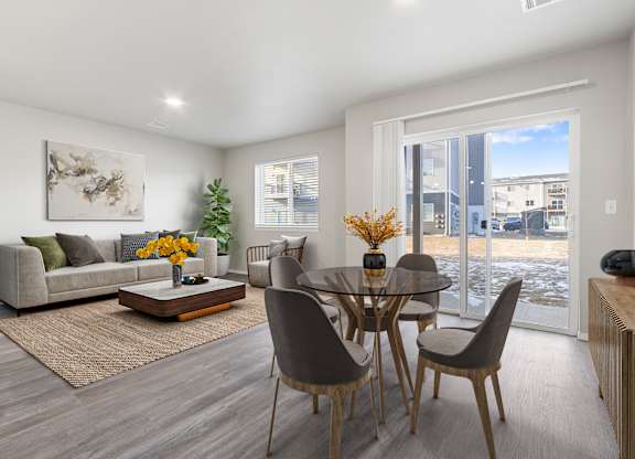 A modern dining room with a glass table and chairs.