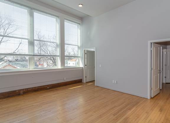 A room with a large window and wooden floors.