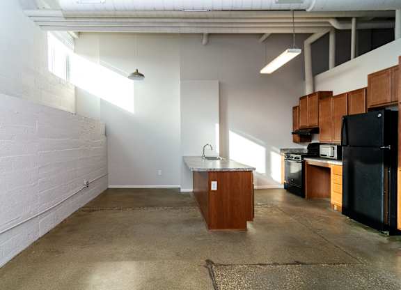 A kitchen area with a black fridge, microwave, and oven.