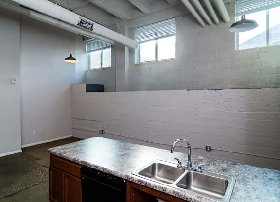 A kitchen with a granite countertop and a double sink.
