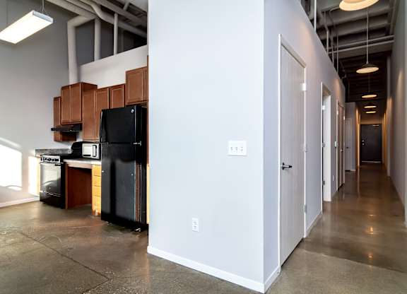 A kitchen area with a black refrigerator and stove top oven.