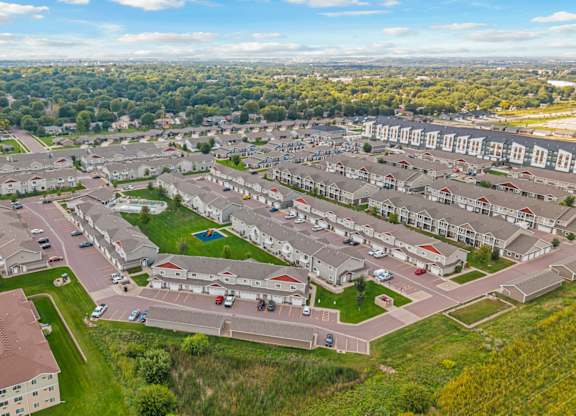 A bird's eye view of a residential area with multiple houses and a parking lot.